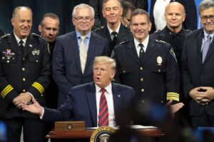 President Trump signs an executive order to create a commission to study the administration of justice after an address to the International Association of Chiefs of Police convention on Oct. 28. (Scott Olson/Getty Images)