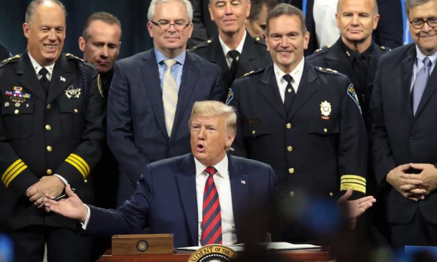 President Trump signs an executive order to create a commission to study the administration of justice after an address to the International Association of Chiefs of Police convention on Oct. 28. (Scott Olson/Getty Images)